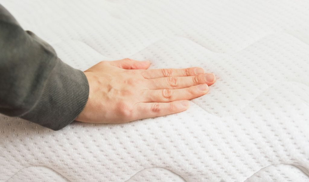 Why choose a foam mattress? 1 Hand pressing on a foam mattress